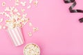 Popcorn bucket and film strip on pink background