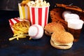 Popcorn and burger, fries and chicken nuggets on the table with draft beer. Baseball party food with balls for the playoffs