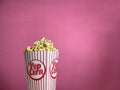 Popcorn in carboard box on pink backround Royalty Free Stock Photo