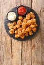 Popcorn chicken is a dish consisting of small bite sized pieces of chicken that have been breaded and fried closeup in the slate