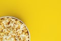 Popcorn closeup viewed from above on yellow background. Flat lay of pop corn bowl. Top view Royalty Free Stock Photo