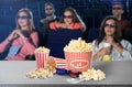 Popcorn, 3D glasses on table and people in cinema hall Royalty Free Stock Photo