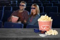 Popcorn, 3D glasses, tickets on table and couple in cinema hall, space for text Royalty Free Stock Photo