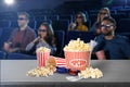 Popcorn, 3D glasses, tickets on table and people in cinema hall Royalty Free Stock Photo