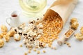 Popcorn, dried corn grains, caramel sauce and oil bottle on kitchen table