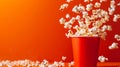 Popcorn exploding from red cup on vivid orange background, dynamic and eye catching scene Royalty Free Stock Photo
