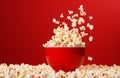 popcorn falling with small corn kernels in colorful bowl on red background Royalty Free Stock Photo