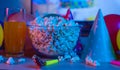Popcorn with festive accessories on the background of TV. Watching TV on the occasion of a family celebration or in a circle of