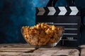 Popcorn film reel and movie clapper on wood background. Screensaver for the inscription of the rest of the viewing of films. Royalty Free Stock Photo