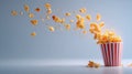Popcorn flying and exploding out of a red and white striped container against a blue background Royalty Free Stock Photo
