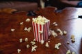 Popcorn flying out of cardboard box. red and white striped popcorn bucket with flying popcorn in the living room, movie or cinema