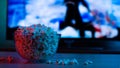 Popcorn in a glass plate on the background of the TV. Color bright lighting, blue and red. Background Royalty Free Stock Photo