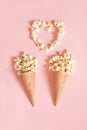 Popcorn in ice cream cones on pink background. Top view. Royalty Free Stock Photo