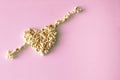 Popcorn laid out in the shape of a heart and arrows, on a pink background Royalty Free Stock Photo