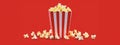 Popcorn in the paper red and white box isolated on the red background Royalty Free Stock Photo