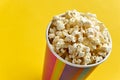 Popcorn in papercup against yellow background