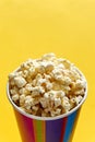 Popcorn in papercup against yellow background