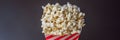 Popcorn in red and white container on a dark background BANNER, LONG FORMAT Royalty Free Stock Photo