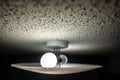 Popcorn textured ceiling with LED bulb light fixture and glass cover Royalty Free Stock Photo