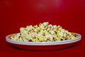 Popcorn viewed from above on red background. Flat lay of pop corn bowl Royalty Free Stock Photo