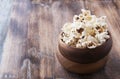 Popcorn in a wooden plate on the background