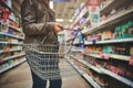 Popping in for a few top ups. a woman holding a basket while shopping at a grocery store. Royalty Free Stock Photo