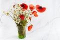 Poppy and daisy wild flowers bouquet on marble background. Floral background.