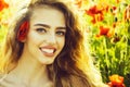 Poppy seed and happy girl with long curly hair in red flower