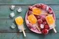 Popsicle. Refreshing fruit ice cream with orange slices served with frozen strawberries, ice cubes. Royalty Free Stock Photo