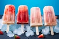 Popsicles and ice cubes arranged on a blue background from above Royalty Free Stock Photo