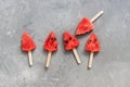 Popsicles on a stick of watermelon in the shape of a Christmas tree on a gray rustic background. Top view, flat lay