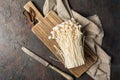 Fresh golden needle mushroom or enoki on wooden cutting board with vintage knife Royalty Free Stock Photo