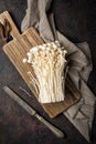 Fresh golden needle mushroom or enoki on wooden cutting board with vintage knife Royalty Free Stock Photo
