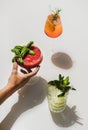 Gin-tonic, Aperol Spritz and Strawberry basil Margarita in womans hand Royalty Free Stock Photo