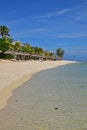 Popular Beach Resort at Le Morne, Mauritius with waving palm trees and sunbathing hut and very clear water
