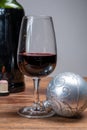 Popular british christmas drink, glass of vintage ruby port wine and christmas tree decoration