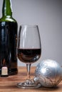 Popular british christmas drink, glass of vintage ruby port wine and christmas tree decoration