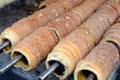 A popular dish among tourists traditional Czech food `Trdelnik` to prepared on a wooden skewers over hot coals