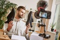 Popular fashion blogger. Young male fashion blogger holding stylish sneakers while making new content for his fashion