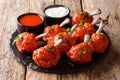 Popular food fried red Lollipops chicken wings served with sauces close-up on a slate board. horizontal Royalty Free Stock Photo