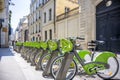 Popular hybrid bicycles with electric motors stand in row on street of Paris ready to ride everyone who wants to rent them Royalty Free Stock Photo