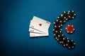 A popular poker game with a combination of three of a kind or set. Chips and cards on a blue table in a poker club. Advertising