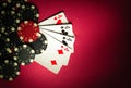 A popular poker game with a winning hand of four of four of a kind or quads. Cards and chips from winning on a red table in a Royalty Free Stock Photo