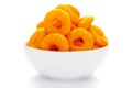 Popular Ready to eat crunchy and puffed snacks ring tangy orange color in a white ceramic bowl. Top view, Royalty Free Stock Photo