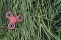 Popular red spinner gadget in 2017 against the background of green grass