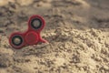 Popular red spinner gadget in 2017 against the background of sand