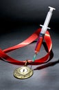 Popular red steroid in syringe as a doping stabs a gold medal on a dark background