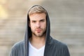 Popular street style. Handsome man with hood standing urban background. Fashion trend. Comfortable clothes daily wear Royalty Free Stock Photo