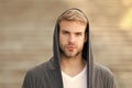 Popular street style. Handsome man with hood standing urban background. Fashion trend. Comfortable clothes daily wear Royalty Free Stock Photo