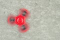 Popular Tri Fidget Hand Spinner spinning on stone background. Royalty Free Stock Photo